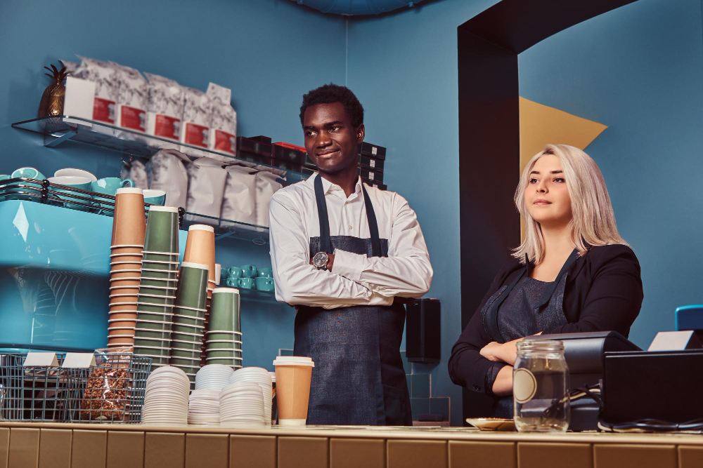 Two baristas ready to serve at the Baraza counter