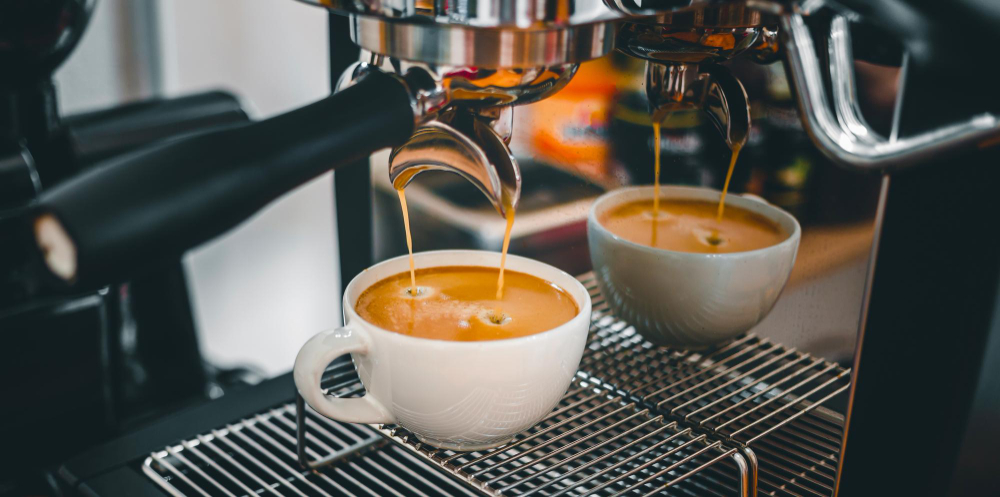 Double espresso pouring from the machine into two cups