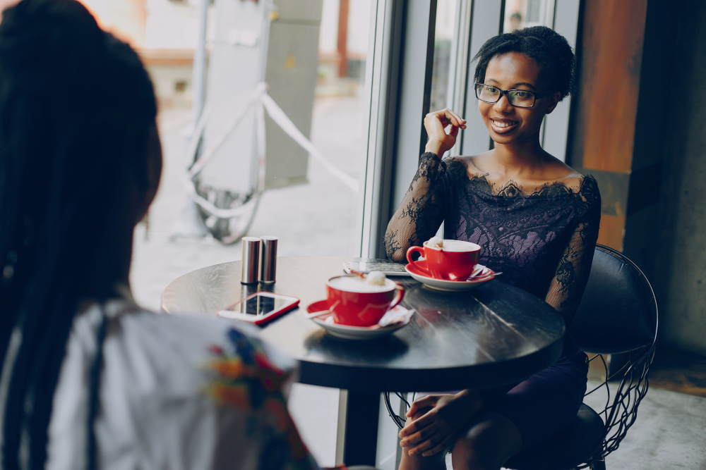 Friends chatting over coffee at a Baraza window seat